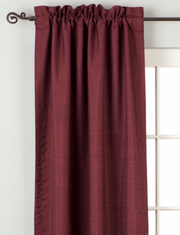 Maroon raw silk rod pocket curtains hung at a window