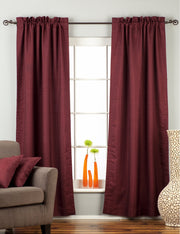 Maroon raw silk rod pocket curtains hung at a window
