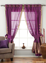Purple sari ring top curtains hung at a window