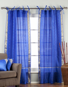 Blue sari tie top curtains hung at a window