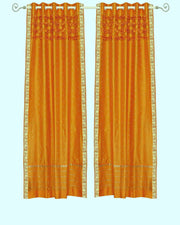 Mustard sari grommet top curtains hung at a window