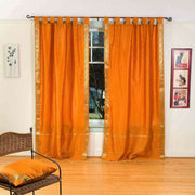 Mustard sari tab top curtains hung at a window