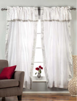 Cream sari rod pocket curtains hung at a window