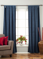 Navy blue velvet tab top curtains hung at a window