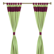 Olive green raw silk tab top curtains hung at a window