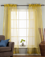 Gold sheer tissue rod pocket curtains hung at a window