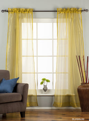 Gold sheer tissue rod pocket curtains hung at a window