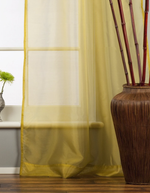 Gold sheer tissue tie top curtains hung at a window