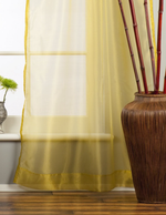Gold sheer tissue tab top curtains hung at a window