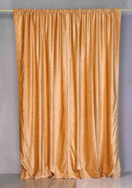 Peach velvet rod pocket curtains hung at a window