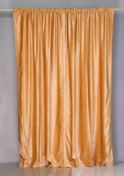 Peach velvet rod pocket curtains hung at a window