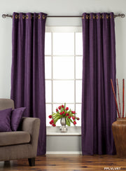Purple velvet grommet top curtains hung at a window