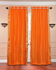 Pumpkin sari grommet top curtains hung at a window