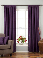Purple velvet tab top curtains hung at a window