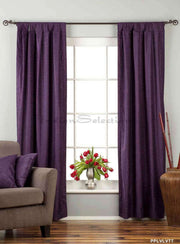 Purple velvet tab top curtains hung at a window