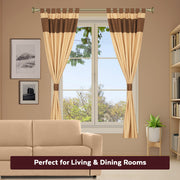 Brown raw silk tab top curtains hung at a window