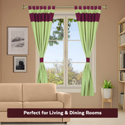Olive green raw silk tab top curtains hung at a window