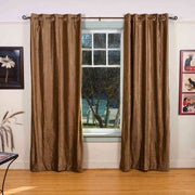 Taupe velvet grommet top curtains hung at a window