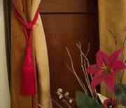 Red sari curtain tiebacks holding a panel open