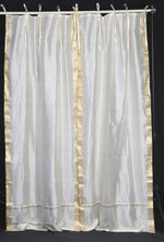 Cream sari tie top curtains hung at a window