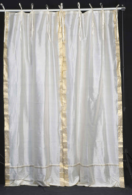 Cream sari tie top curtains hung at a window