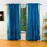 Turquoise sari rod pocket curtains hung at a window