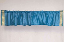 Turquoise sari valance mounted above a window