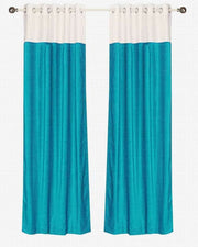 Turquoise velvet ring top curtains hung at a window