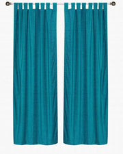 Turquoise velvet tab top curtains hung at a window
