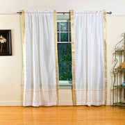 White sari rod pocket curtains hung at a window