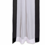 Black sheer tissue rod pocket curtains hung at a window