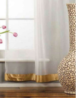 White sheer tissue rod pocket curtains hung at a window
