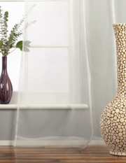 White sheer tissue tie top curtains hung at a window