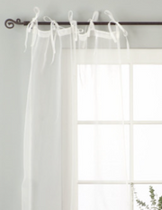 White sheer tissue tie top curtains hung at a window