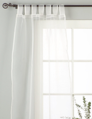 White sheer tissue tab top curtains hung at a window