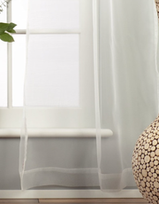 White sheer tissue rod pocket curtains hung at a window