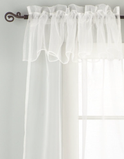 White sheer tissue rod pocket curtains hung at a window
