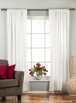 White velvet rod pocket curtains hung at a window