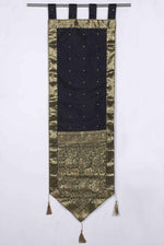 Black sari wall hanging displayed on a wall