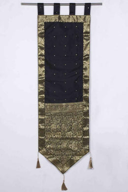 Black sari wall hanging displayed on a wall