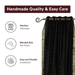 Black sari grommet top curtains hung at a window