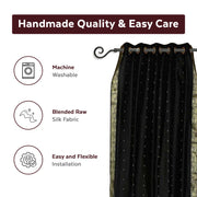 Black sari grommet top curtains hung at a window