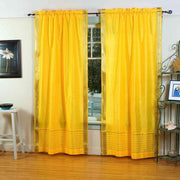 Yellow sari rod pocket curtains hung at a window