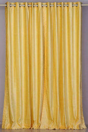 Yellow velvet grommet top curtains hung at a window